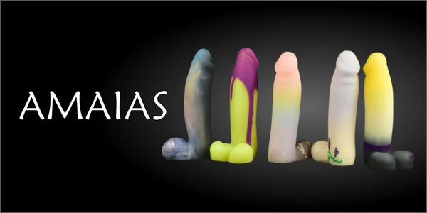 Header banner reading "AMAIAS" alongside a row of five colorful silicone dildos against a black background.